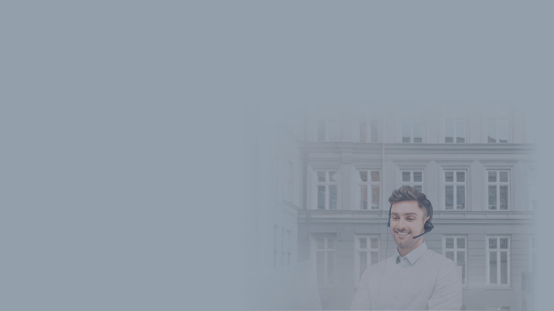 Smiling man speaking on a headset with a building in the background